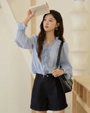 Women's blue ruffled tie-front loose-fit shirt, featuring 100% lyocell with a silky drape and self-tie V-neck for romantic elegance from office desk to evening dinner.