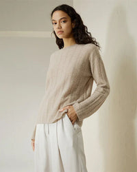 Woman brunching in a Semi-Sheer Cable-Knit Baby Cashmere Sweater, 100 % baby cashmere and open-stitch cables give airy 90s vibes—your luxe yet breathable 70-85 °F summer statement.