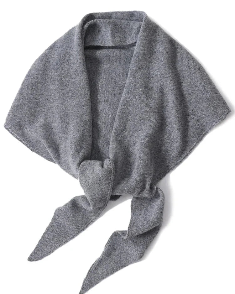 An oversized 100% wool triangle wrap shawl with a soft knitted texture, designed to drape elegantly over coats and knits for versatile warmth.