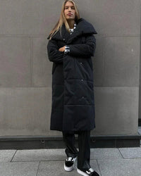 Broad quilting gives the surface a clean, understated rhythm, complemented by a statement collar and matching belt.