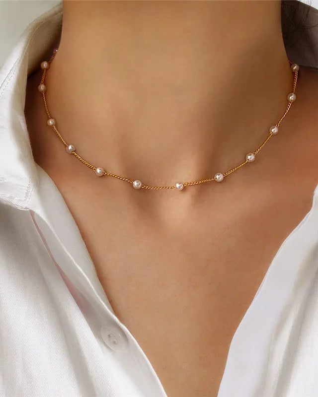 A vintage-inspired choker necklace featuring lustrous glass pearl beads on a delicate gold-tone chain, secured with a lobster clasp for a timeless look.