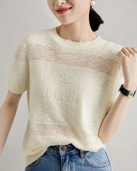 A short-sleeved wool knit top with a round neck, designed for a minimalist summer look; it pairs well with sneakers and boots.