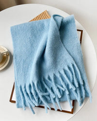 This oversized knitted scarf offers generous coverage — long enough to drape, wide enough to layer — while its clean, solid finish keeps the look refined.