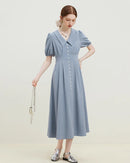 Fine pleats add visual texture, while the polo neckline and voluminous sleeves lend the silhouette distinctive character.