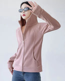 Woman street-styling a slim-fit zipper-up hoodie, 90 % cotton / 10 % spandex fleece contours the body—thumb-hole cuffs and hip-length cut keep you warm on breezy 55-70 °F spring runs.