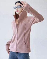 Woman street-styling a slim-fit zipper-up hoodie, 90 % cotton / 10 % spandex fleece contours the body—thumb-hole cuffs and hip-length cut keep you warm on breezy 55-70 °F spring runs.