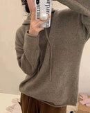 Woman lounging in the 2023 Autumn-Winter New 100 % Cashmere Hoodie, 19-micron Mongolian fibers and relaxed drop-shoulders give cloud-soft warmth—your luxe yet breathable 55-70 °F cold-season essential.