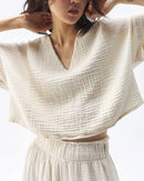 Women's cotton muslin V-neck top with sheer gauze texture and relaxed short sleeves—airy statement piece for tropical getaways, rooftop cocktails or summer street strolls.