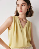 Woman layering a V-neck solid-color commuter mulberry-silk sleeveless shirt, sand-beige 19 momme fabric drapes effortlessly—your breathable, temperature-regulating base for 70-85 °F summer office days.