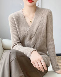 Women’s merino-wool V-neck pullover with cross-twisted front and relaxed long sleeves—sculptural layer for office days, weekend cafés or gallery openings.