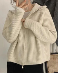 Woman city-strolling in a zipper-lapel 100 % cashmere short coat, 19-micron Mongolian fibers and notch-lapel zip front give refined edge—your luxe yet breathable 45-65 °F fall-to-spring commuter layer.